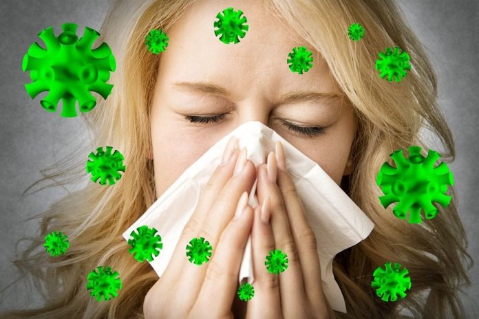 Ill woman with tissue is sneezing virus
