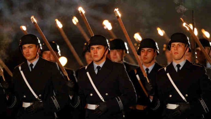 Soldiers with lit torches attend a Grand Tattoo of the German Armed Forces Bundeswehr for former President Christian Wulff at the presidential Bellevue palace in Berlin