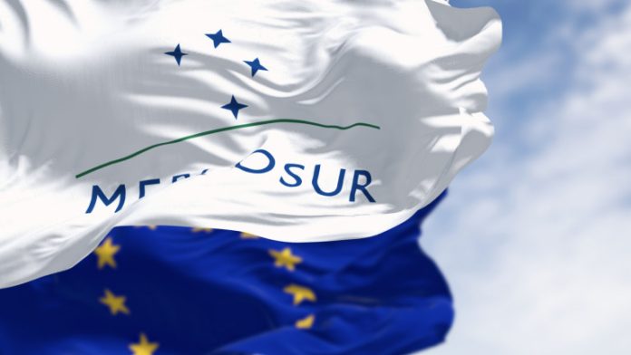 Flags of Mercosur and European Union waving in the wind on a clear day
